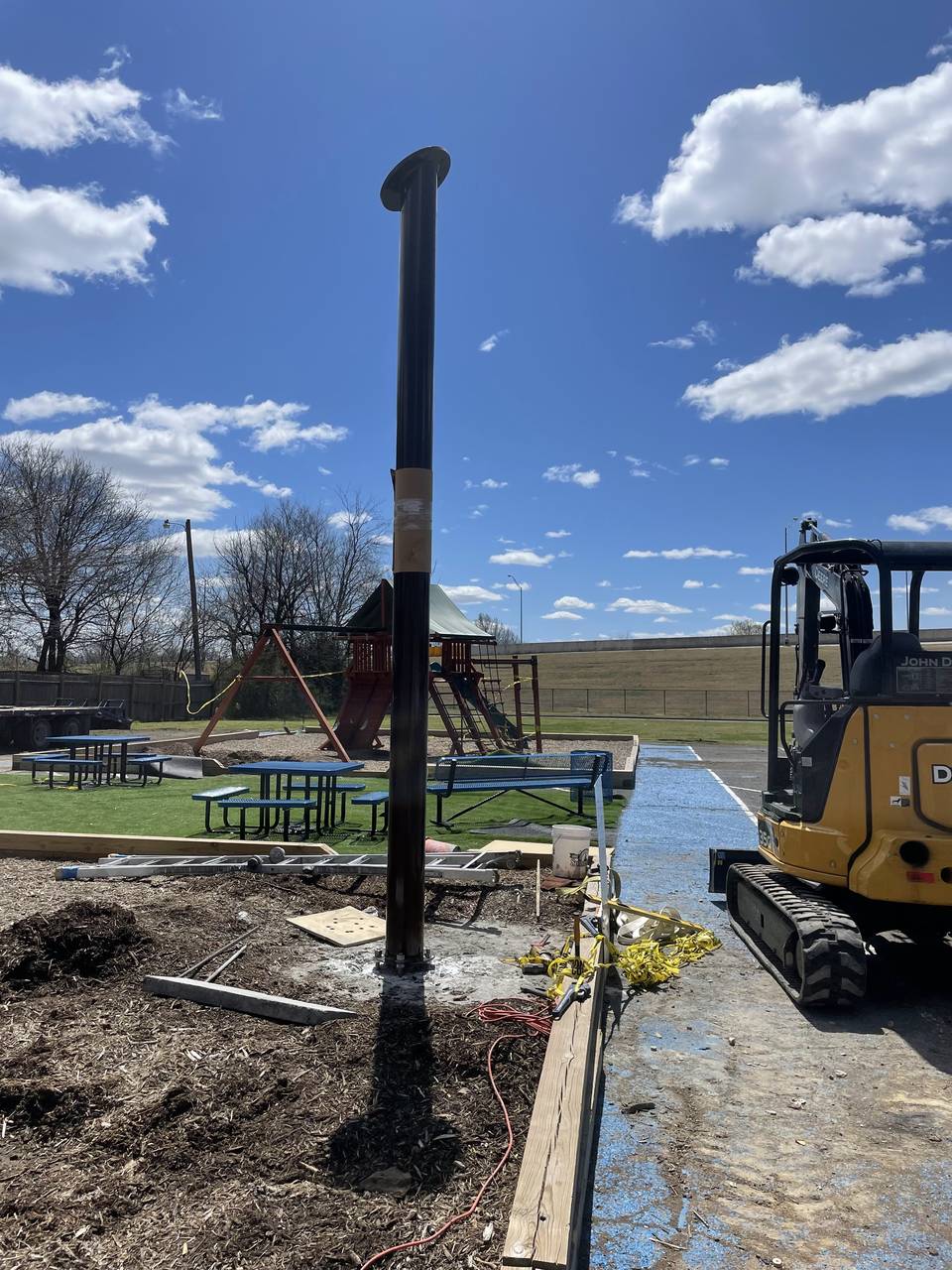 Galvanized steel pier and bracket transferring a foundation load beside Oklahoma clay soil