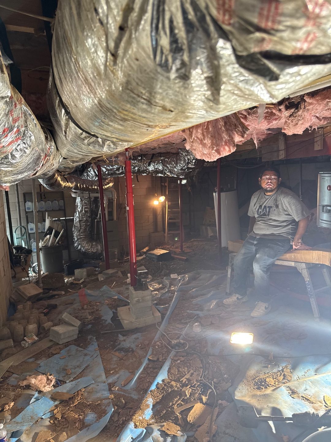 Crew completing structural support work in a residential crawl space